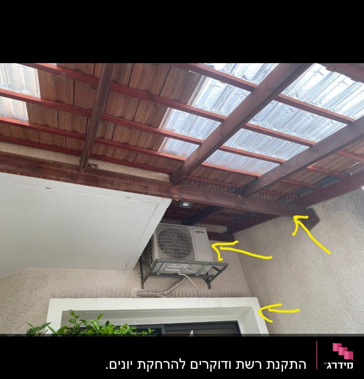 מזגן מותקן על קיר עם דוקרנים למניעת יונים